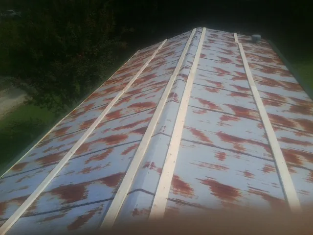 Rusted metal roof panels with new wood purlins before replacement — Storm Damage Roof Repair in Rock Stream by Roofing Brothers
