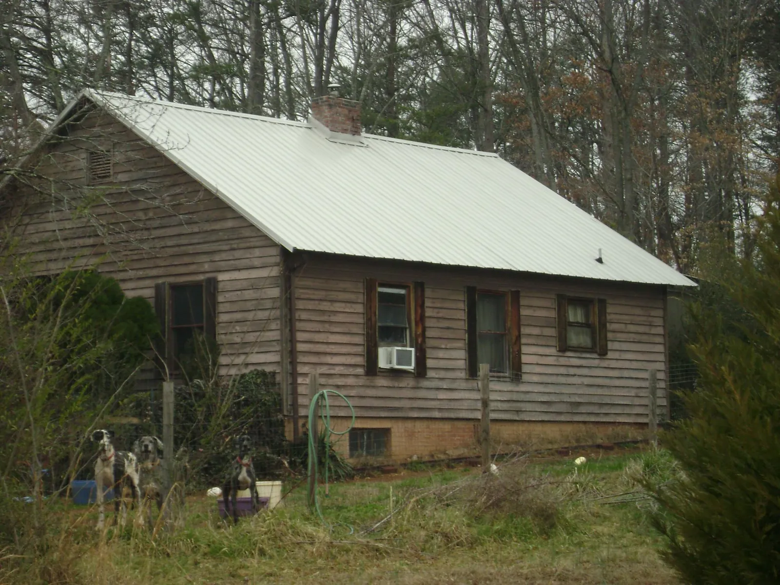 White metal roof on an old wood sided farmhouse, from a Metal Roof Installation job in Rock Stream